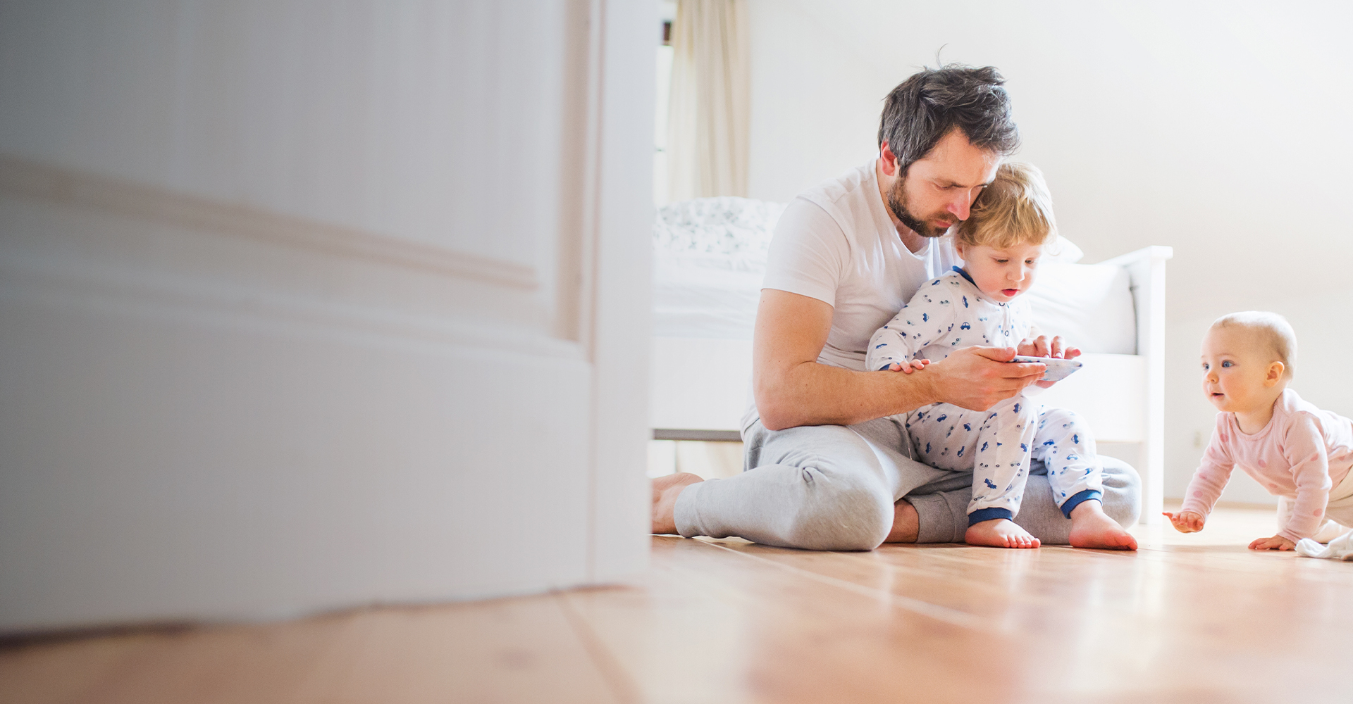 Mom and daughter playing with tablet on hard surface floor